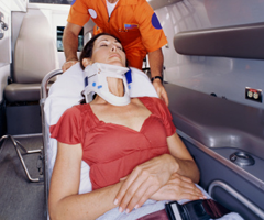 Paramedic carrying an injured woman into the ambulance after auto collision